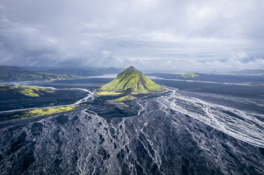 M&aelig;lifell green volcano rising from black sand plain, Iceland