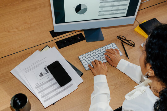 Top View Businesswoman Typing at Office Desk With Reports