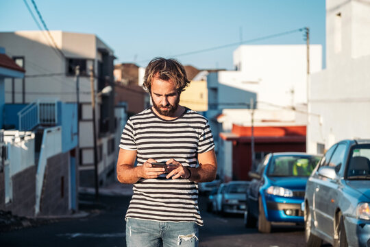 Young man using smartphone on urban street