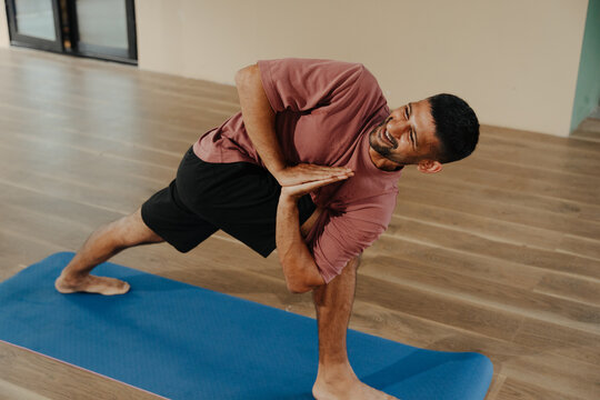 Man Practicing Yoga in a Studio During a Morning Session