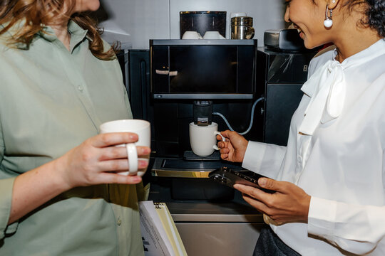 Colleagues Preparing Coffee at Office Coffee Machine