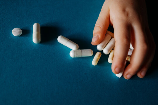 Child hand reaching pills. Medication concept