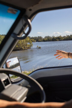 Anonymous friend reaching from van by river in Yamba Australia