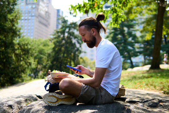 Man takes in his meal in Central Park, NYC.