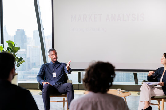 Market analysis presentation with diverse audience in modern office.