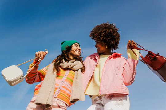 Happy friends carrying bags enjoying day out together