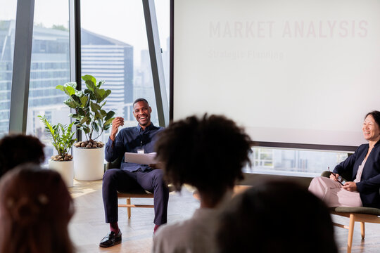 Market analysis presentation with diverse audience in modern office.