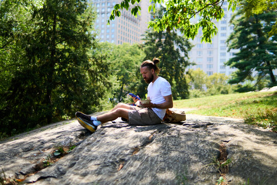 Man savors his meal in Central Park, NYC.