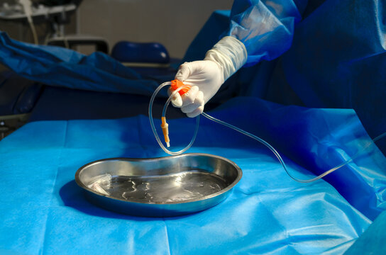 the hands of a nurse preparing to administer an IV