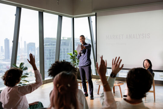 Speaker leads market analysis presentation with audience participation