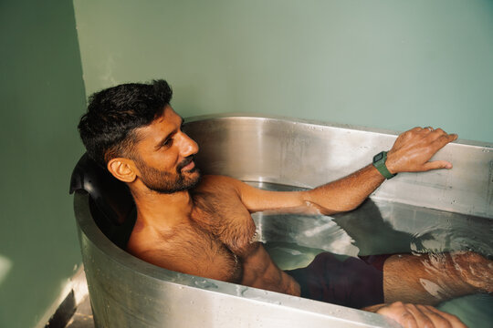 Men sitting in a bathtub, rejuvenating with ice water