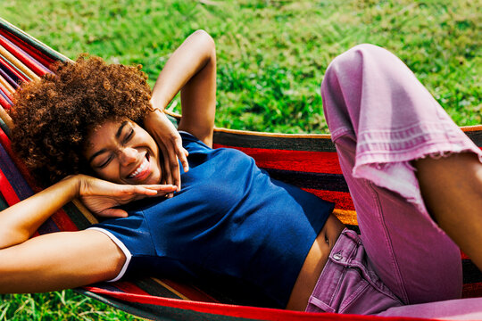 Person relaxing in hammock enjoying summer nature