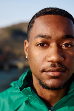 Portrait of young black adult looking at the camera outside
