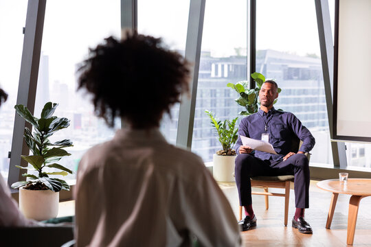 Business presentation in modern office with large windows.