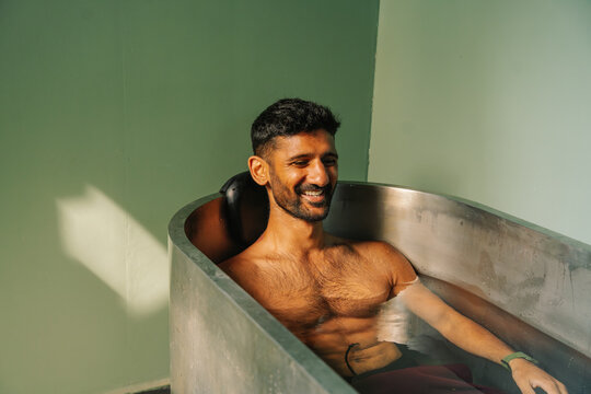 Man recovering in a Metal Bathtub with an ice bath in a Room 