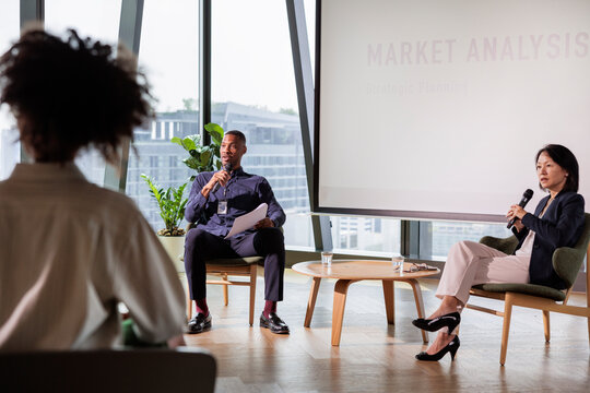 Business professionals present market analysis to an audience.
