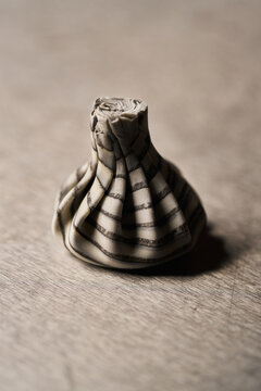 Raw striped khinkali dumpling on metal surface