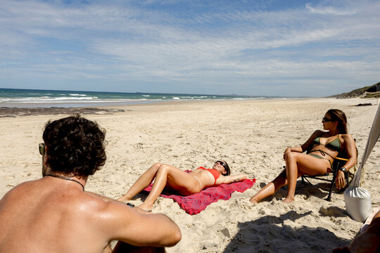 UGC mixed friends sunbathing on beach in Australia