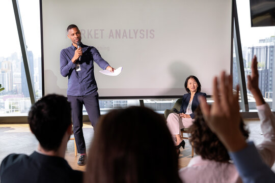 Speaker presenting market analysis to an engaged business audience
