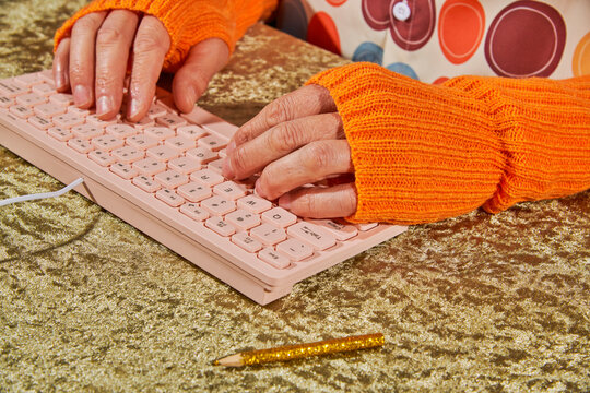 side view of a man typing on a pink keyboard
