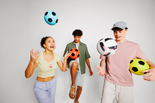 Diverse group juggling colorful soccer balls