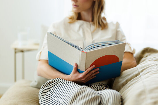 Woman Reading a Book on Couch
