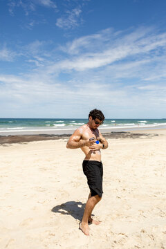 UGC man applying sunscreen on beach in New South Wales
