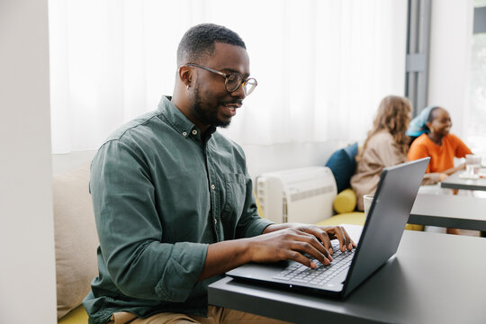 Man Works on Laptop in Cafe During the Day