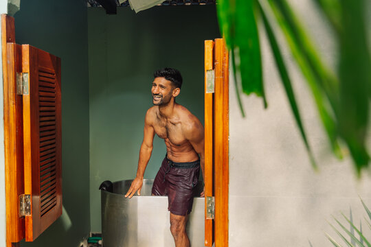 Man Exits Bath With a Smile in a Tropical Setting During the Day