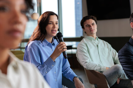 Woman speaks at a conference with audience members listening.
