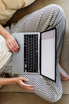 Person Working Remotely On Laptop While Relaxing At Home