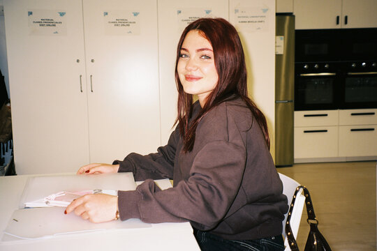 Young woman sitting at desk in classroom