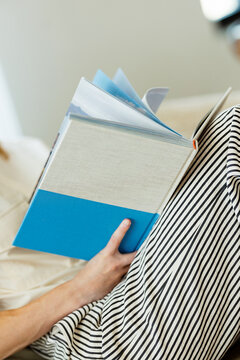 Woman Reading Hardcover Book at Home