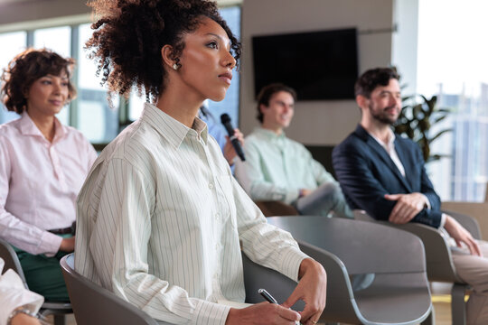 Diverse audience attentively listens at a business conference.