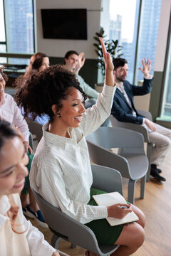 Woman raising hand during an interactive team workshop in office
