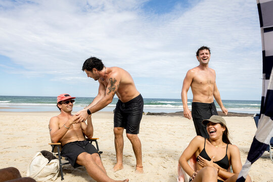 UGC Group of mixed Friends laughing together on beach in Australia