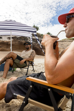 Men drinking mate on beach in Australia