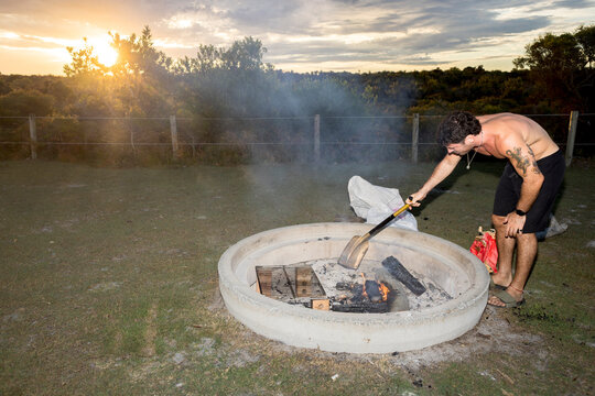 ugc Man tending campfire at campsite in NSW Australia