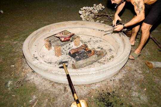 UGC Man placing wood on campfire at campsite in Australia with flash