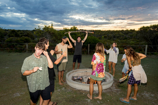 UGC Mixed friends having fun by campfire at campsite in Australia 