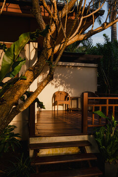 Wooden deck by a house with a chair in a golden hour