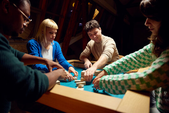Friends Playing Board Game During Evening 