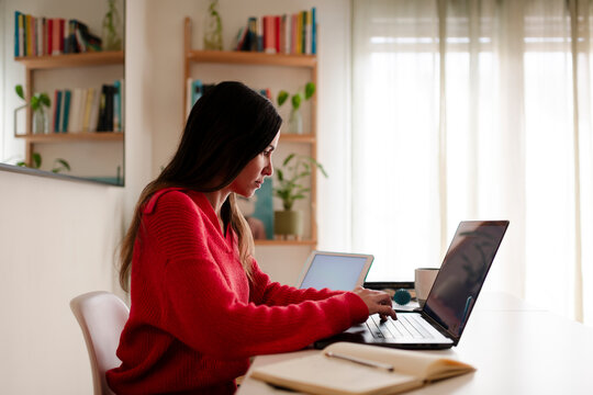 Focused Woman Typing on Laptop at Home Office