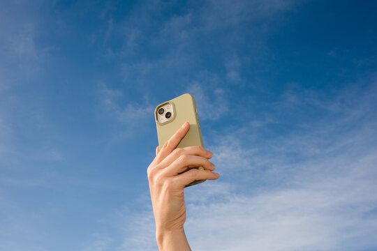 Hand Holding a Phone At Blue Sky 