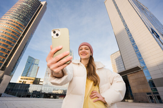 Woman Using Phone To Do A Selfie In The City