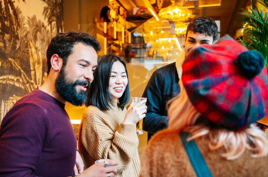 Diverse friends socializing and drinking at bar