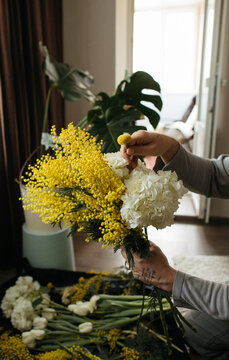 Anonymous crop man doing bouquet at home