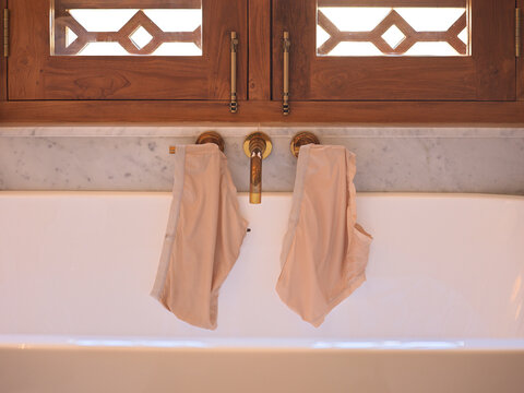 Two Pairs of Panties Hung to dry on hotel Bathtub
