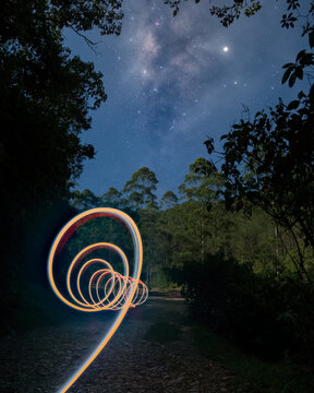Light painting spiral path under starry night sky