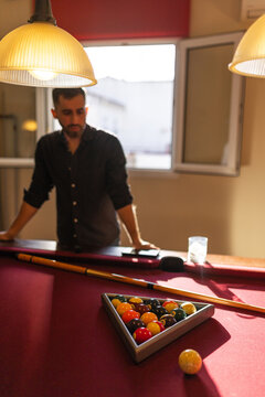 Man standing and observing billiard table at home